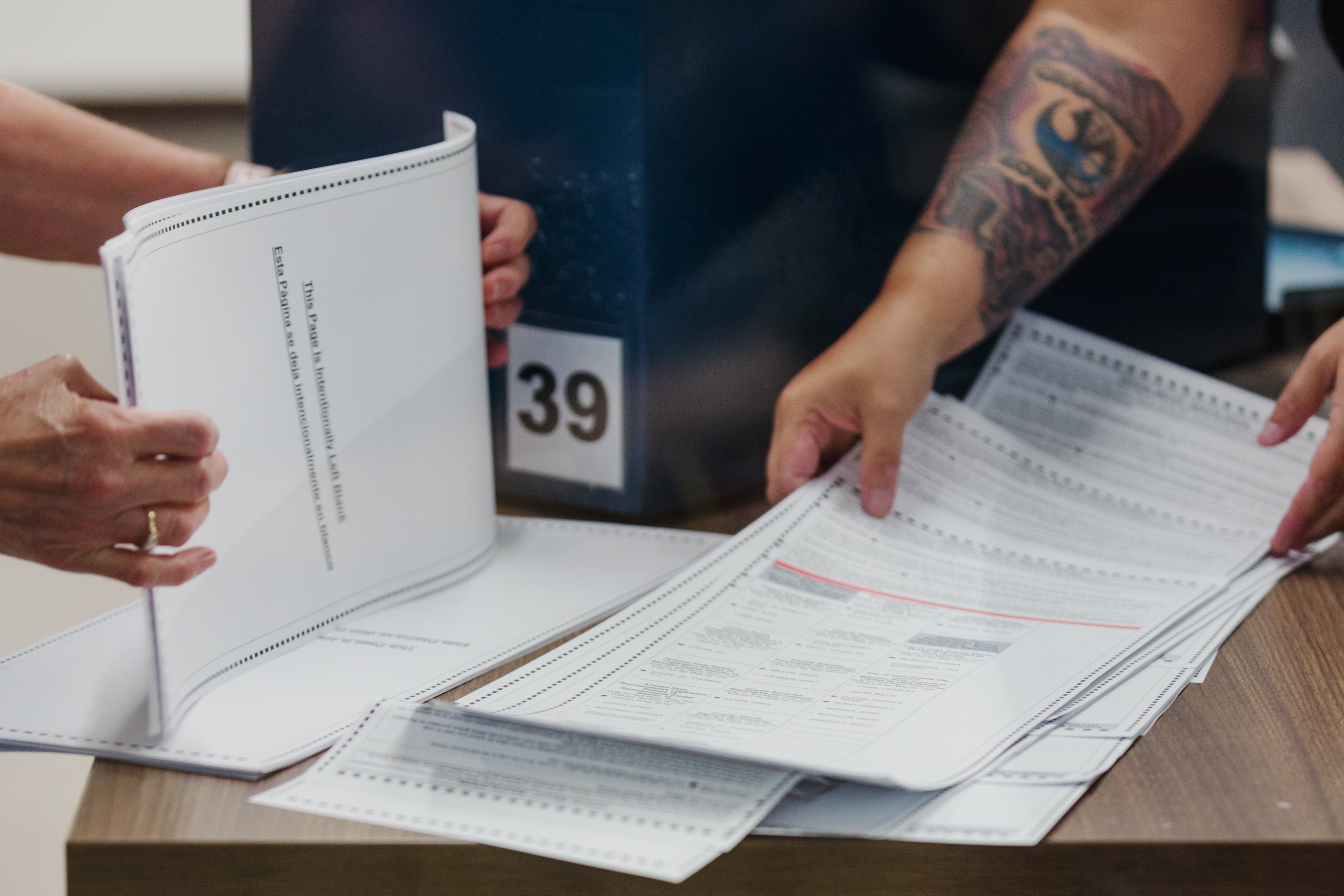 voter filling out a paper ballot at a table